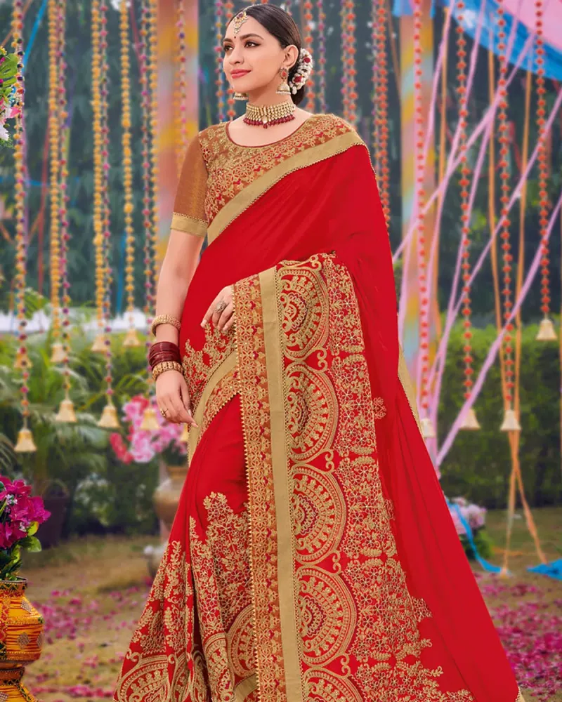 A woman in a red saree with rich gold embroidery